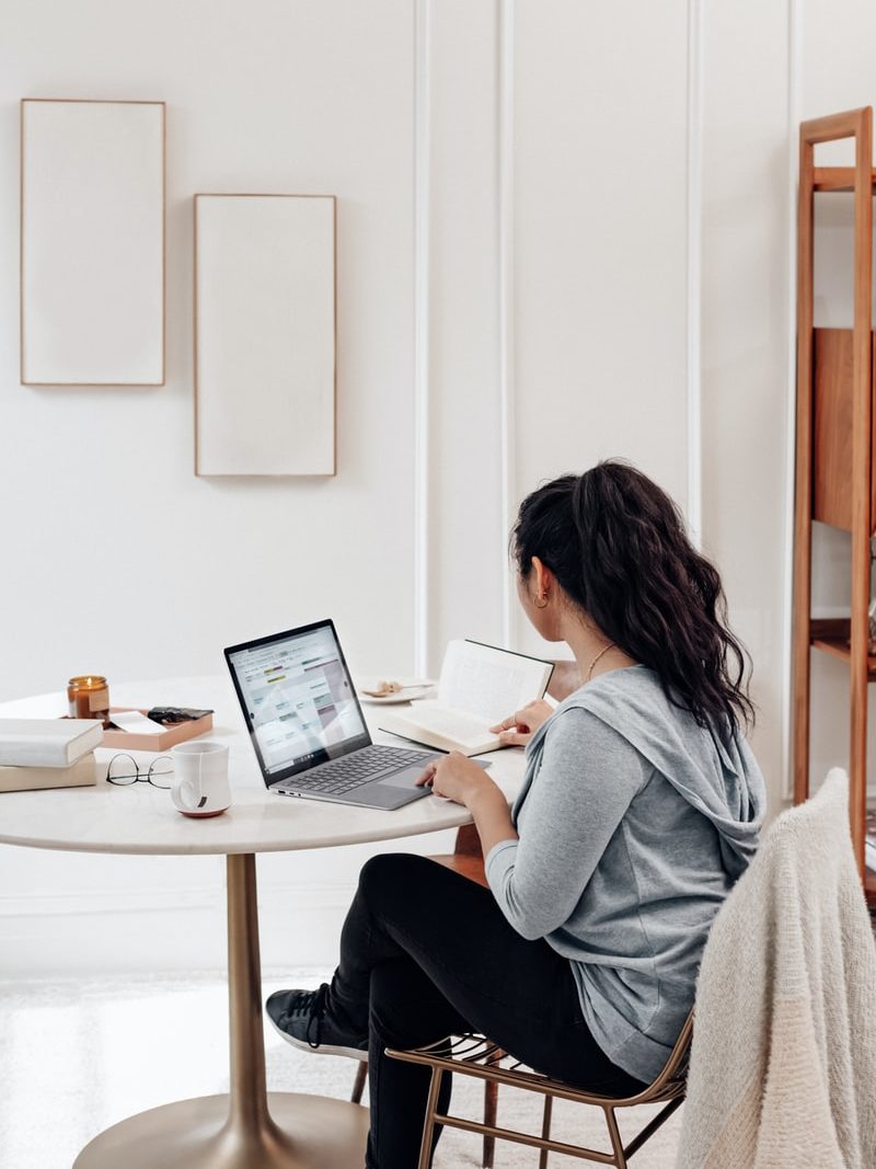 Foto von Windows woman in gray sweater using microsoft surface laptop